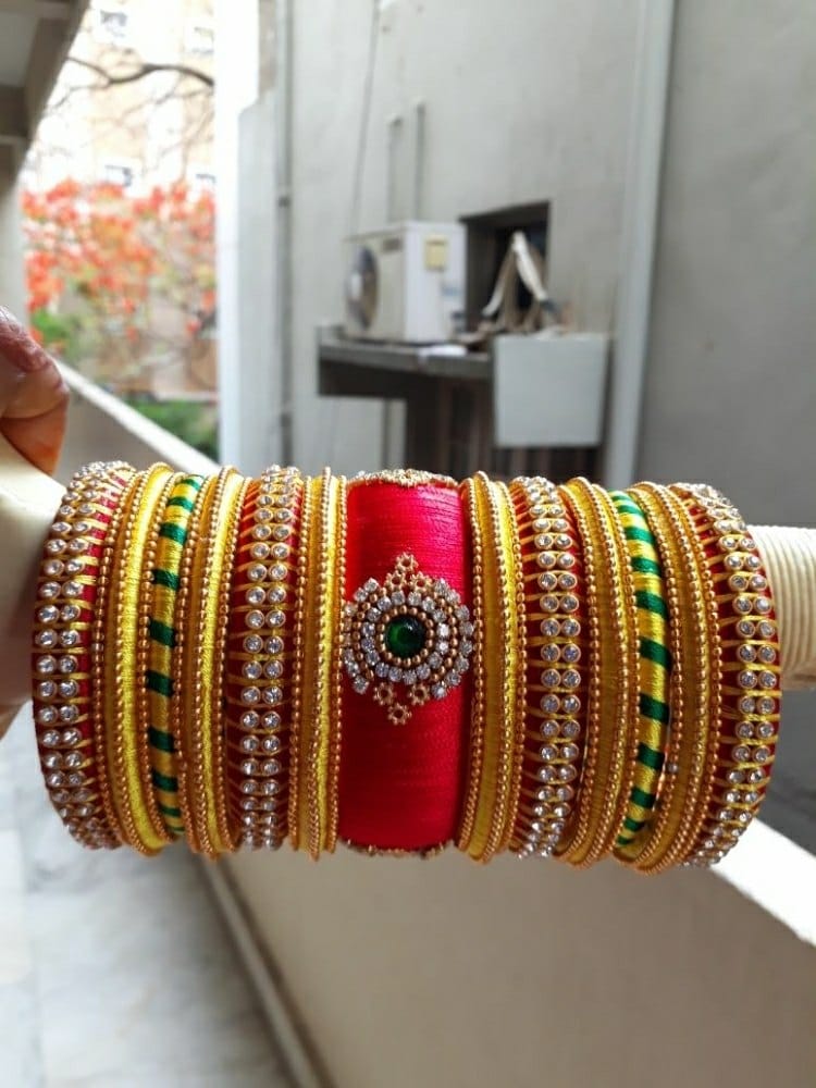 Gold and red bangles with green thread work